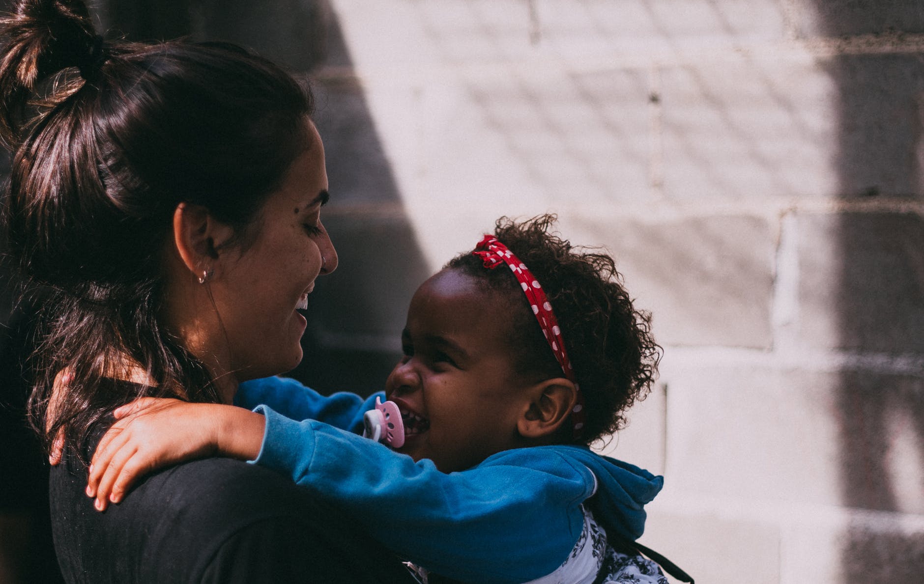 A woman is holding a baby and smiling.