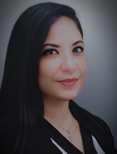 A woman with long black hair wearing a white shirt.