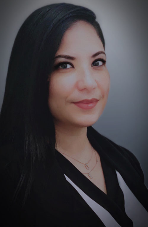 A woman with long black hair wearing a white shirt.